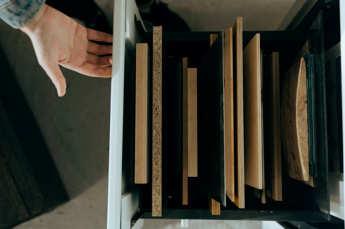 Holzplatten in verschiedenen Stärken und Materialien im Vergleich – Echtholz, Furnier und Holzwerkstoffe in einer Schreinerwerkstatt.
